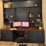 a desk with a computer and shelves in a room