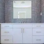 a bathroom with a mirror above the sink